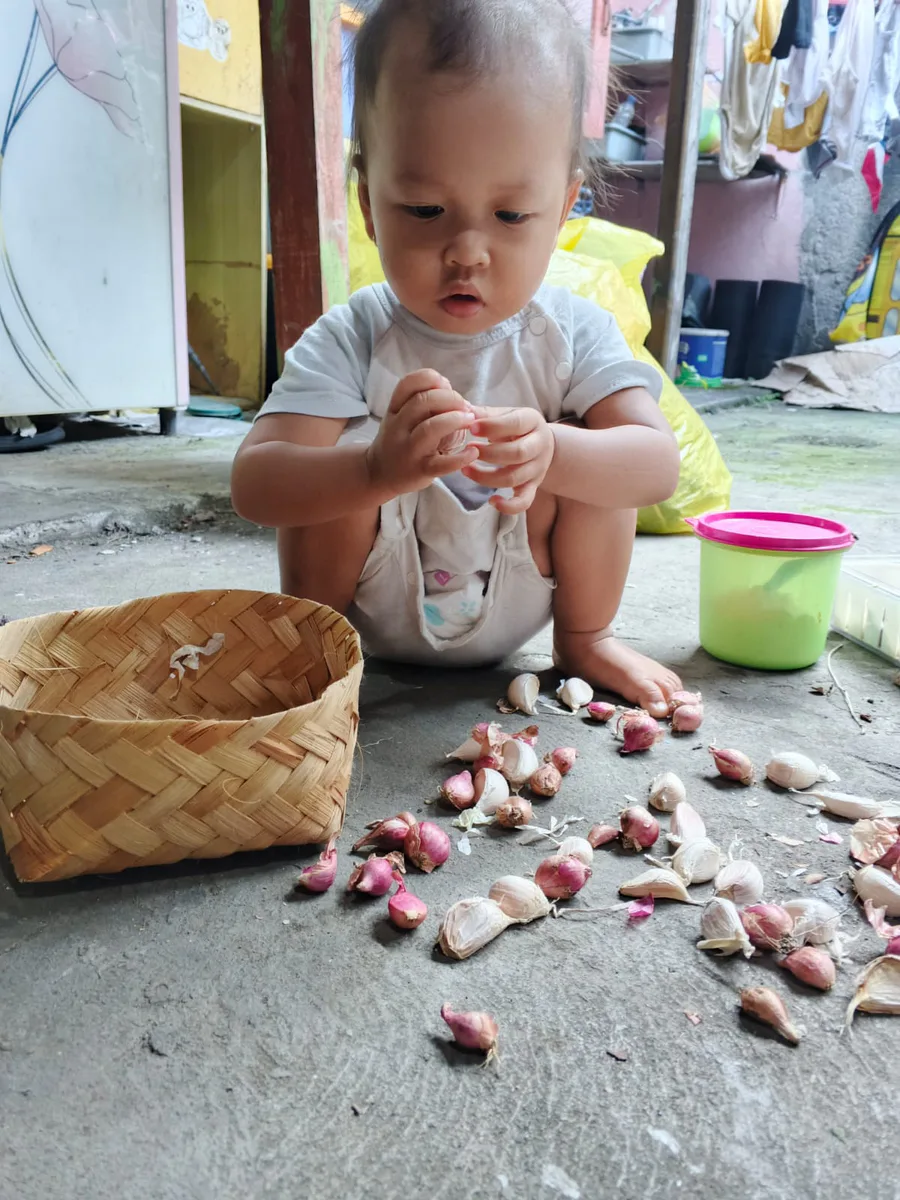 Anak bermain dan mengeksplorasi bahan dapur di rumah